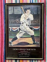 Full view of framed Babe Ruth poster featuring artwork of Babe Ruth at bat in stadium setting with crowd and bunting background.