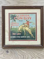 Full framed vintage Florida Cowboy brand fruit box label with cowboy on horse illustration and text.