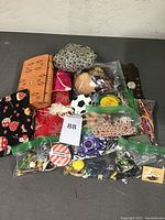 Overview of mixed costume jewelry bags with various items including beaded necklaces, brooches, pins, and bracelets