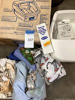 Photo showing Dr. Scholl's foot bath massager in white plastic, original box with instructions, assorted linens, and decorative seashells in front.