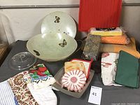 Assorted kitchen items displayed including butterfly ceramic plates, kitchen towels, pot holders and oven mitts.