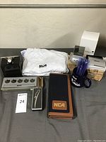 Overview photo of entire Nippon Cargo Airlines memorabilia collection showing T-shirts, clocks, business card holders, coffee mug, pens, and other items