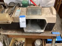 Front view of Sears lapidary machine with transparent lid showing polishing section and stones below.