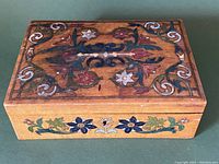Top view of the antique Viennese hand painted lidded box showing intricate floral and vine patterns on the lid.