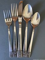 Five-piece place setting: dinner fork, dessert fork, knife, soup spoon, teaspoon