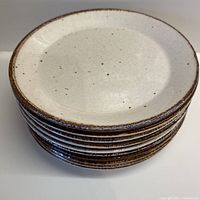 Stack of 8 J&G Meakin Lifestyle plates showing cream speckled pattern and cinnamon rim color.