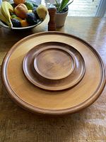 Top-down image of the wooden lazy Susan on a rustic wooden table showing natural wood grain and smooth surface.
