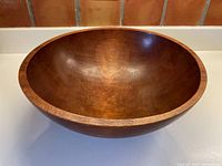 Front view of large wooden bowl showing the smooth polished interior surface and natural wood grain