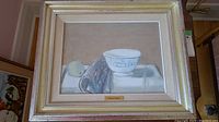 Full view of framed still life painting with blue and white bowl, cloth, fruit, and brass name plaque