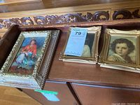 Three miniature framed art pieces displayed side-by-side on a wooden carved surface, showing decorative frames and colorful portrait paintings.
