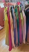 View of nine ladies jackets in assorted colors and styles hanging on a rack.