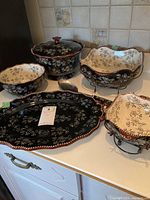 Full view of the serving set including platter, bowls, spoon, and covered bowl showing decorative floral lace pattern.
