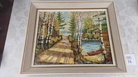 Full view of framed oil painting depicting a lakeside dirt path with birch trees and a canoe near a cabin by the water.