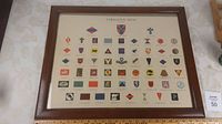 Oak framed print showing a full view of the formation signs with multiple colored insignia arranged in rows.