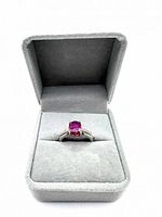 Front view of ring set in gray velvet box