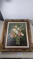 Full view of floral painting in elaborate gold and brown gallery frame measuring 32 x 26 inches.