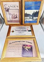 Four 5x7 framed canoe-themed postcards displayed two standing upright, two lying flat, showing vintage styled prints and wood-tone frames without glass.