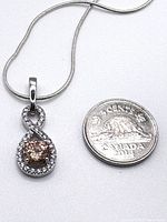 Pendant beside 2014 Canadian 5-cent coin for scale
