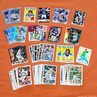 Photo showing variety of 2023 Topps Series 2 baseball cards, including base cards duplicates, inserts, parallels with holographic finishes. Features some star players and All-Star cards.
