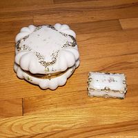 Full set showing the smaller and larger porcelain trinket boxes placed on wooden surface.