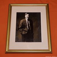 Full view of the framed autograph photo showing the entire frame, matting, and the image of Conan O'Brien in suit, signed in black marker.