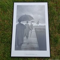 Framed black and white poster showing three figures walking on a pier, one figure flying, with motivational quote on bottom