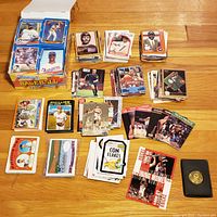 Top view of the lot spread out showing assorted sports and promotional cards, some duplicates, and a card holder