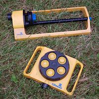 Yellow Gilmour oscillating sprinkler with black adjustable controls on grass.