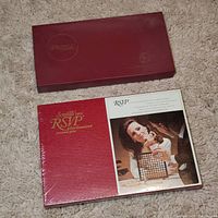 Photo of sealed Scrabble RSVP board game box showing vintage packaging and artwork with players using the 3D tile holder.