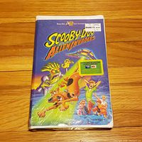 Front cover of the sealed Scooby-Doo and the Alien Invaders VHS tape showing colorful alien and Scooby-Doo characters.