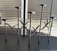 Front view of wrought iron fireplace candle stand showing five candle holders and curved design.