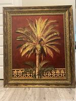 Framed painting of a single palm tree with gold ornate frame on red background, large size 49x42 inches