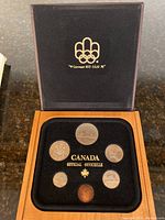 Top open view showing the 6 Canadian coins in black velvet display with Olympic emblem on lid.