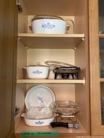 Photo showing upper shelf with large CorningWare casserole dish with blue floral pattern and glass lid.
