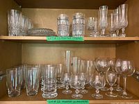 Shelf with assorted cut crystal glasses, small bowls, and stemmed glasses