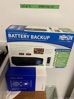 Box of Tripp Lite home theater/computer battery backup UPS system with key features and image of unit.