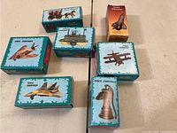 Photo showing boxed miniature diecast pencil sharpeners in the shapes of horses, trains, airplanes, space shuttle, and pump.