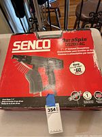 Front of box showing brand, model DuraSpin DS200-AC, and features like reversible operation and screw range 1-2 inches.