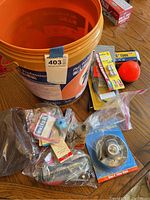Photo showing the bucket and assorted bicycle parts including tube, tools, packages