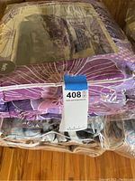 Packed twin comforter sheet set with floral and geometric purple patterns in plastic packaging