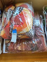 Photo of two colorful comforters packaged in plastic showing their geometric and circle designs in bright colors.