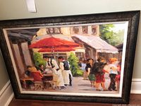 Full view of the framed painting showing the cafe scene with tourists and waitstaff, outdoor setting with umbrellas and awnings.