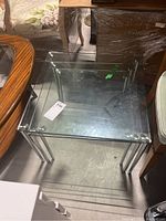Overview of the three nesting tables, stacked and showing chrome legs and transparent glass tops