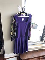 Photo of purple Joseph Ribkoff dress with matching patterned shirt and jacket hanging on a stand.