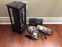 Full lot overview with jewelry box, stainless steel serving utensils, pineapple candle snuffer, and place card holders.