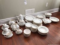 Wide view of set showing plates, bowls, serving dishes with lids, teapot, coffee pot, cups and saucers