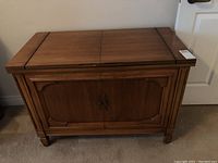 Full front view of the cabinet showing closed top and cabinet doors with wood finish.