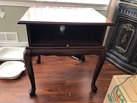 Full view of the solid wood telephone table showing curved legs and pull-out shelf below.