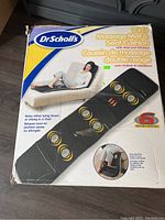 Box of Dr Scholls 2-in-1 Massage Mat and Seat Cushion with Heat and Vibration, showing product image and branding