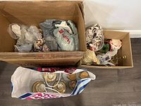 Photo showing two boxes and a shopping bag filled with wrapped glass and ceramic Christmas ornaments and figurines.